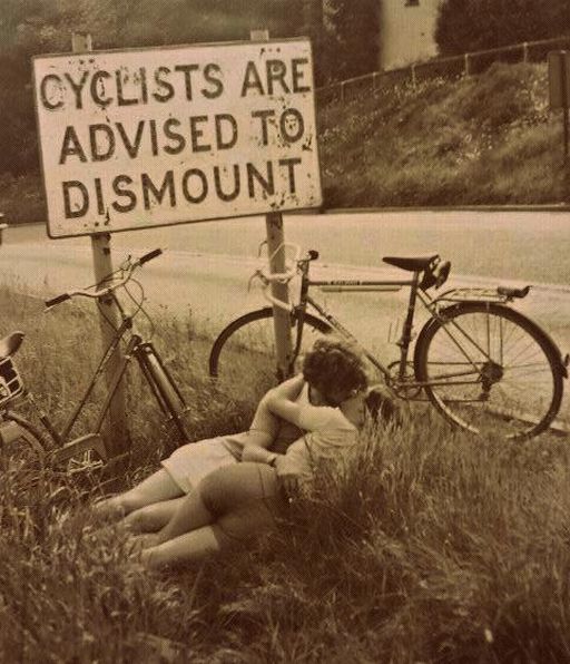 bicyclists kissing by the side of the road