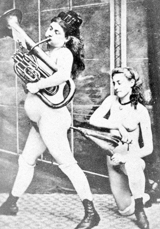 woman playing a brass instrument being \"inflated\" by an anal bellows