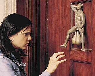 girl reaching for brass balls door knocker