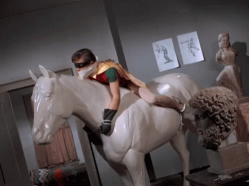 batman stands pat robin bound and gagged on white marble horse gif