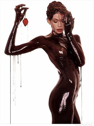 naked woman covered in chocolate syrup and holding a strawberry
