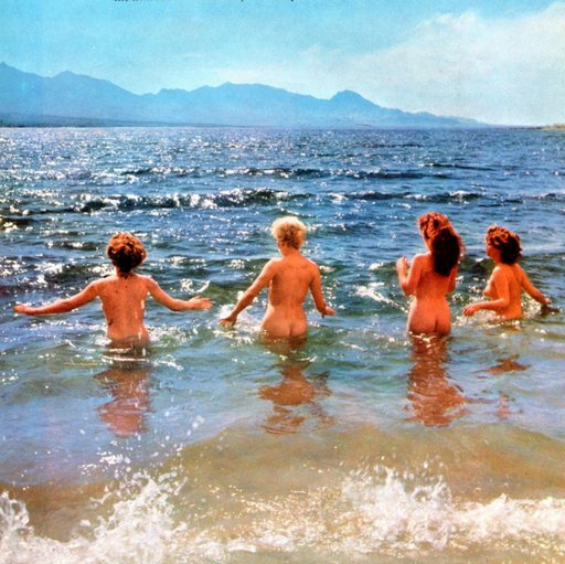 four nude women wading out into the ocean to go skinnydipping