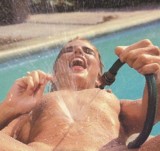 woman appears to orgasm as she squirts garden hose water on her chest
