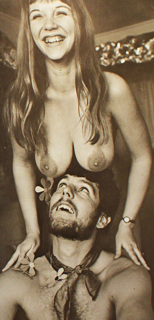 flower children nudists hangout: hippie chick with a big smile dangles her boobs over a happy bearded man