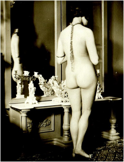 nude flapper woman in her boudoir at her dressing table and mirror