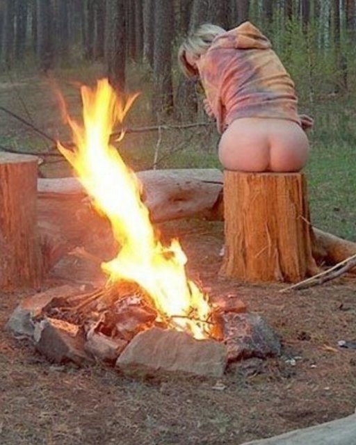 woman warms her bare bottom by a crackling fire
