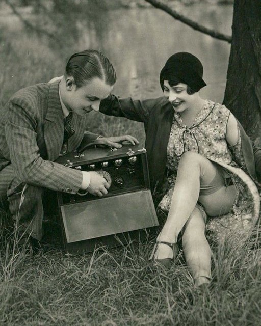 tuning his vintage portable tube radio for a seduction in the park