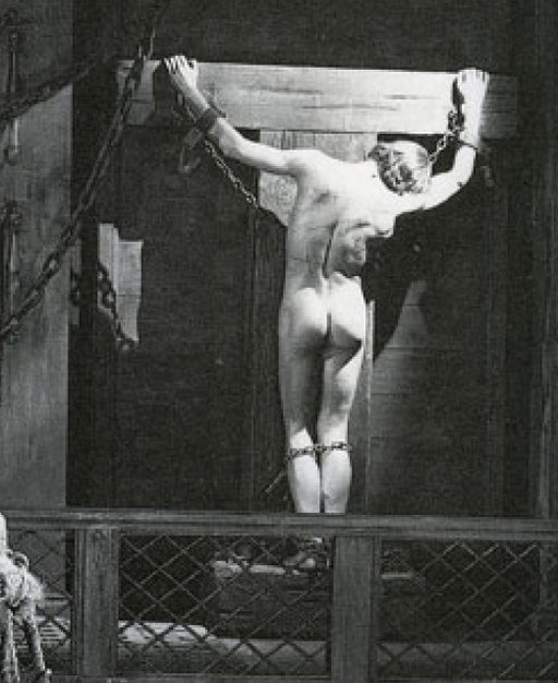 naked male chained whipped Roman galley slave tied to a cross for punishment