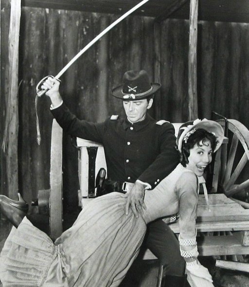 television promotional photo of a woman getting spanked with a cavalry sword - actually a wife spanking