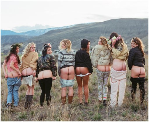 eight beautiful women in sweaters and faux fur coats flashing their pretty butts at the photographer in front of a nice view from a height