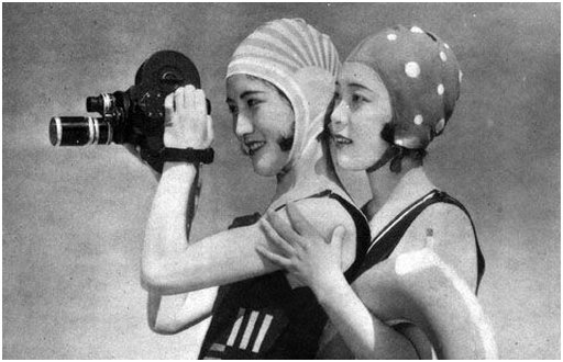 swimcap lesbians on a japanese beach playing with a film camera