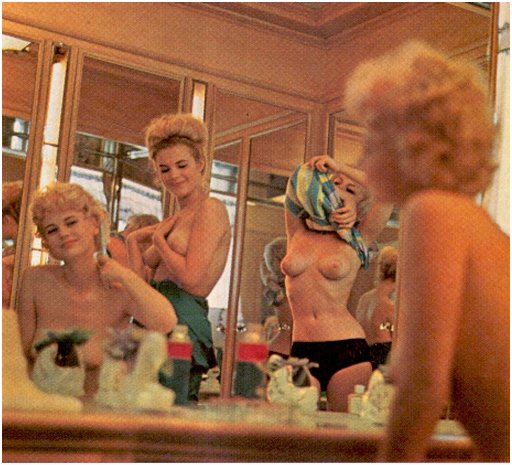 three topless blonds prepping their hair and makeup for a bikini contest