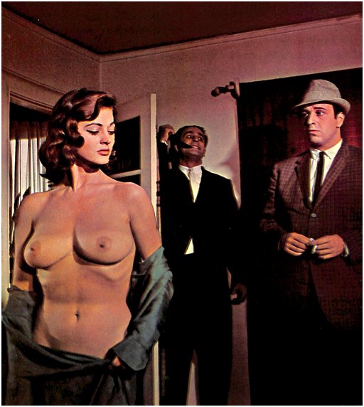 a chilly brunette bares her breasts to a man in a suit while a crazy dude with a knife lurks behind the door