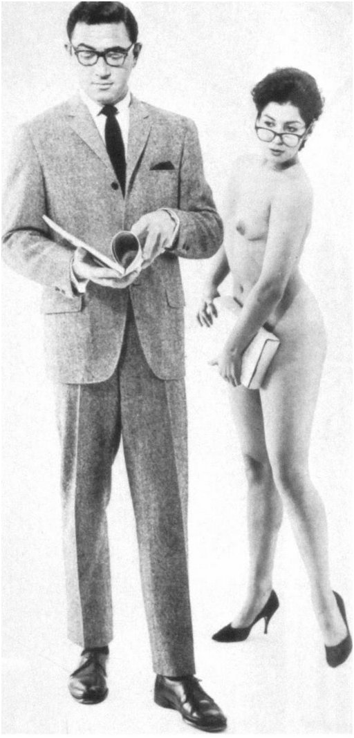 man in a sharp suit is getting the eye from a nude woman with pretty glasses and a book hiding her bare pussy