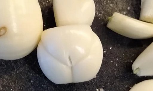 peeled clove of garlic that looks like a belly and legs and pubes and bare shaved pussy