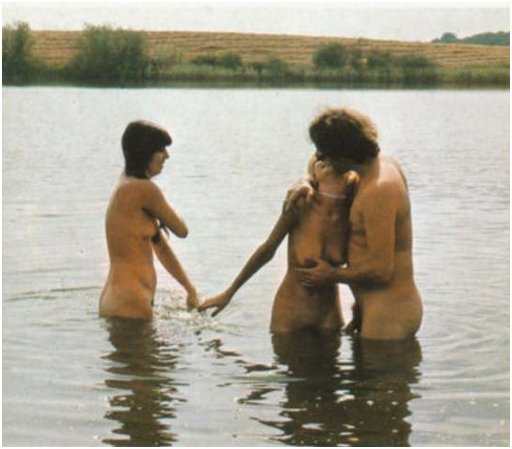 nude threesome splashing around in a pond