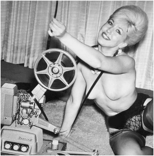 topless blonde projectionist wearing a garter belt and fancy stockings