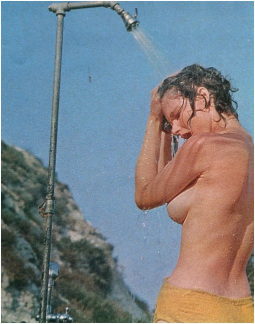 washing the sand out of her hair at a beach shower station