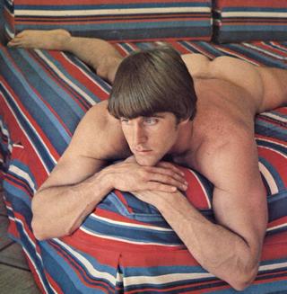 naked man on a long-out-of-style striped bedding set
