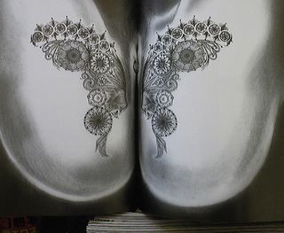 a beautiful butterfly tattooed around her pussy