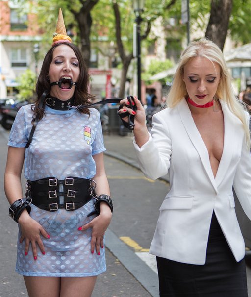 humiliated slave with ice cream melting on her head as she walks on a public street in spain