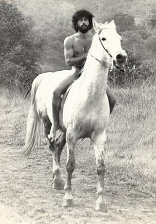 nude hippy man on a white horse