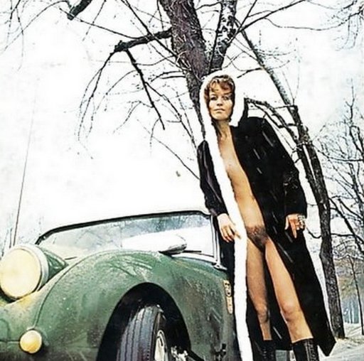 chilly porn star posing in fur coat by a fancy car in the snow