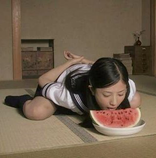 japanese girl eating a watermelon with her hands behind her back