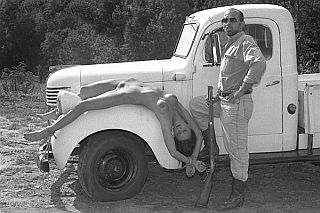 nude woman tied to fender of truck like game