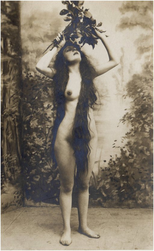 woman with lots of hair posing with foliage
