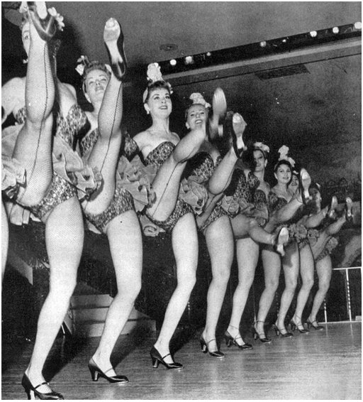 nine chorus girls showing off the seams of their stockings