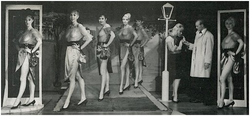 seven women in transparent but very high class stripper outfits on the chorus line at a London strip joint